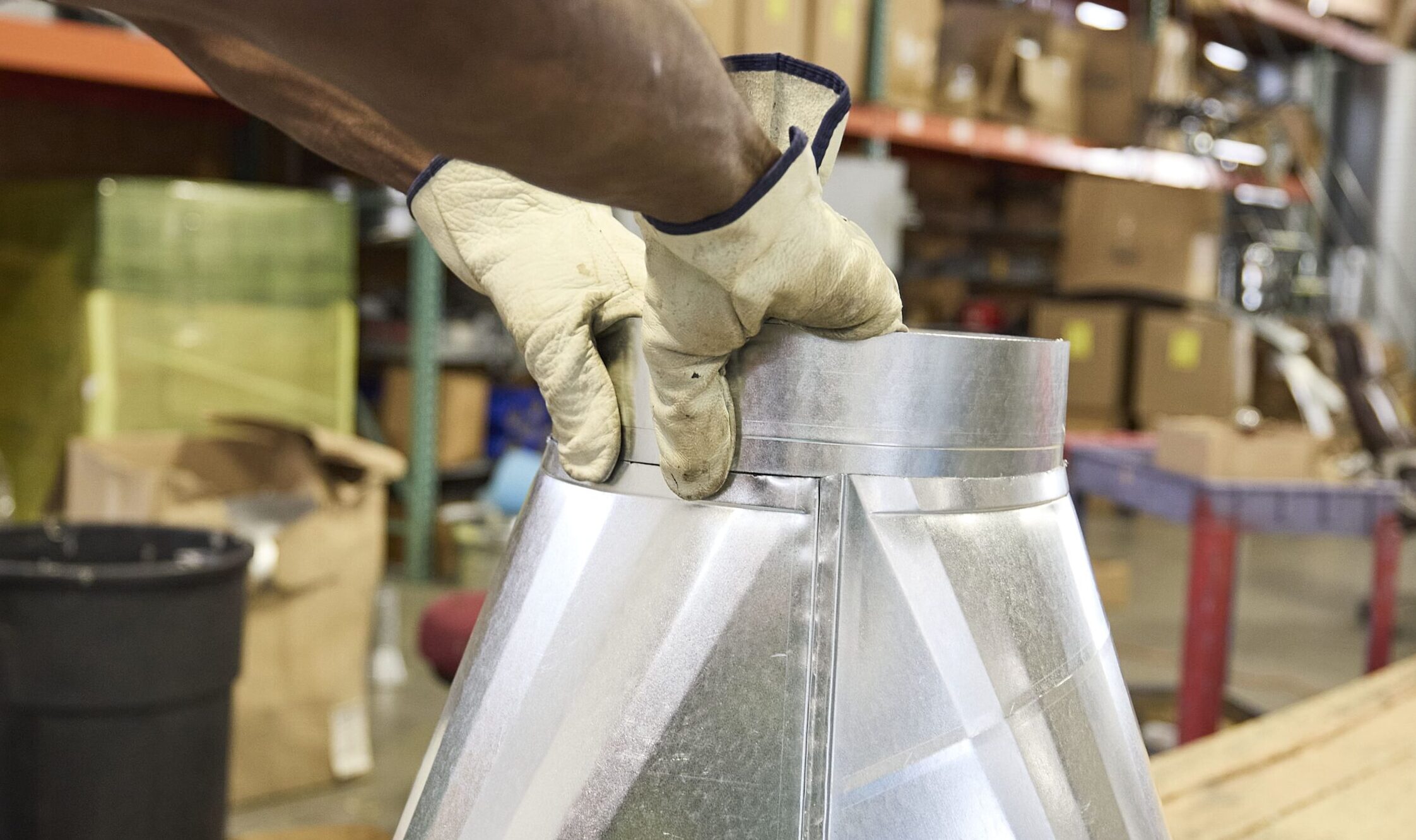 Two gloved hands working with custom fabricated metal