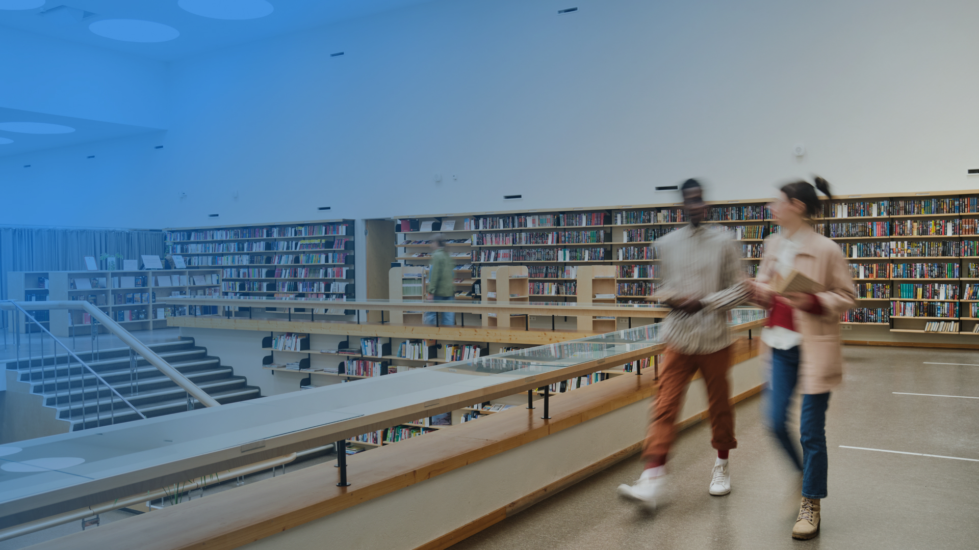 Two students walking through a library